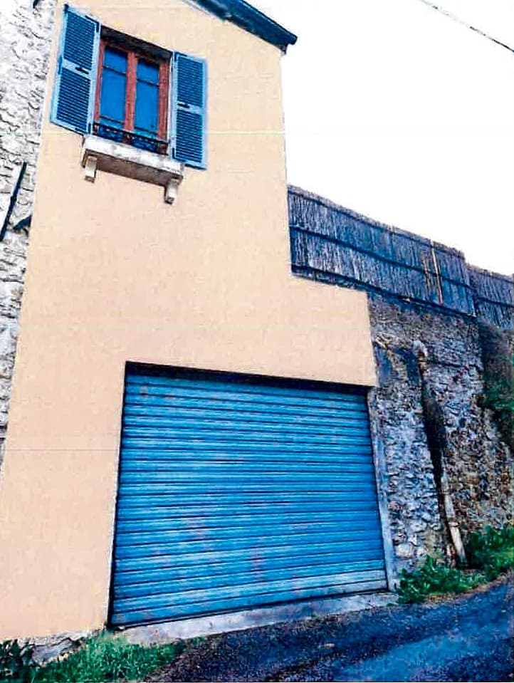 Ravalement d’une maison de village en pierre — Le garage, repris dans la même teinte que la maison, après travaux